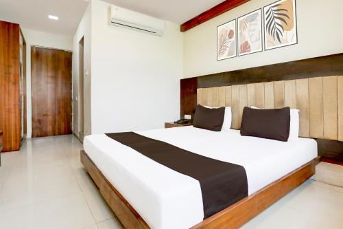 a bedroom with a large bed in a room at Super Townhouse Prahladnagar in Ahmedabad