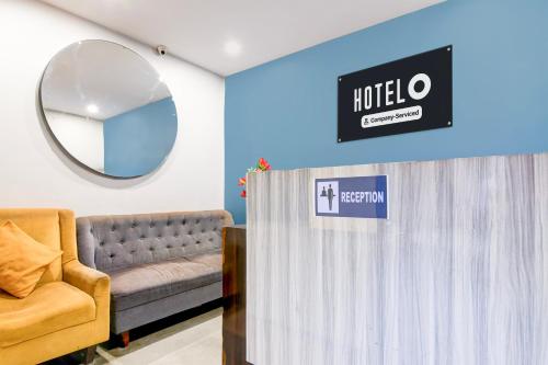 a hotel room with a couch and a mirror at Super Hotel O Picnic Garden formerly Amaris Stay in Kolkata
