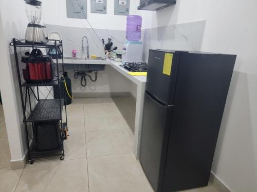 a kitchen with a black refrigerator next to a counter at CAMILLE 2 Excelente ubicación Familiar in San Cristobal