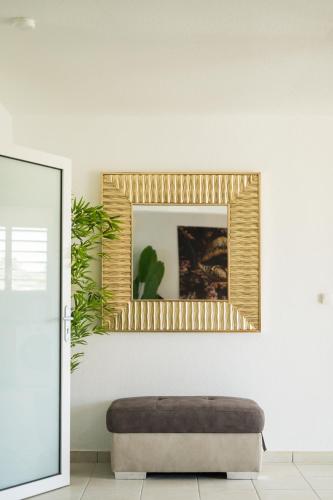 a living room with a mirror and a ottoman at L évasion Doré in Le Gosier