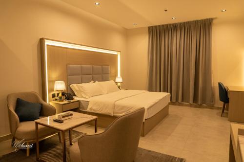 a hotel room with a bed and a table and chairs at serene stay اقامة هادئة in Dammam