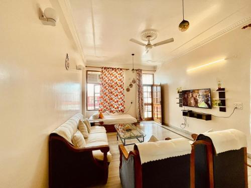 a living room with two couches and a tv at Golden Healing Journeys Homestay in Rishīkesh
