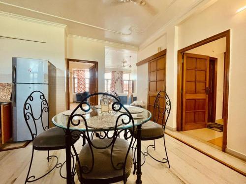a dining room with a glass table and chairs at Golden Healing Journeys Homestay in Rishīkesh