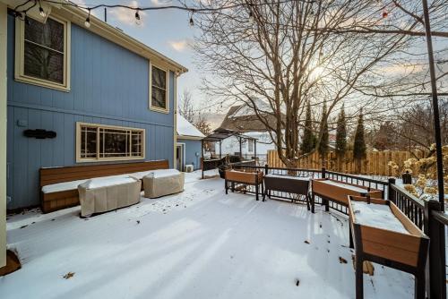 a snow covered yard with benches and a house at EPIC Group Stay Big Gameroom Bar Arcade Playroom in Olathe