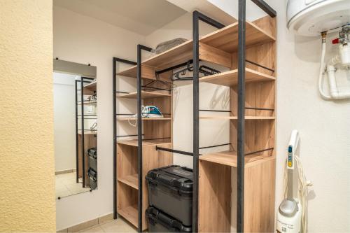 a walk in closet with wooden shelves and a suitcase at L évasion Doré in Le Gosier