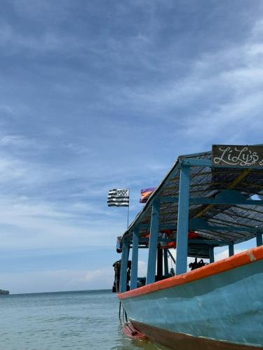 a boat sitting in the water on a beach at Lily's Beach Bungalows in Koh Rong Island
