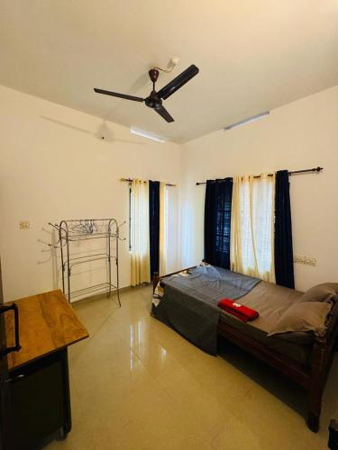 a bedroom with a bed and a ceiling fan at MOON VILLA 01 varkala 3bhk with kitchen in Varkala