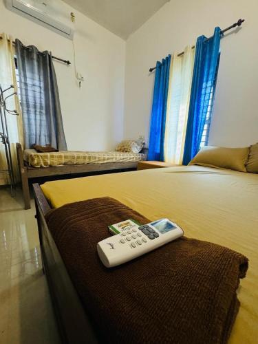 a remote control sitting on top of a bed at MOON VILLA 01 varkala 3bhk with kitchen in Varkala