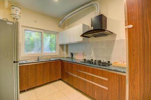 a kitchen with wooden cabinets and a sink and a stove at Golden Healing Journeys Homestay in Rishīkesh