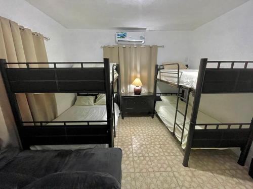 a room with three bunk beds and a lamp at Casa Marina Miramar in Ciudad Madero