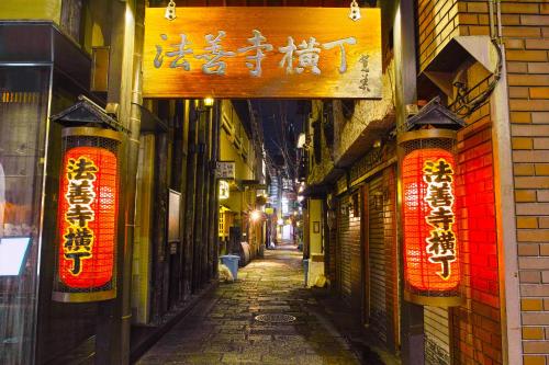 an alley with signs on the side of a building at ゆいの宿大阪城east1号室 in Osaka