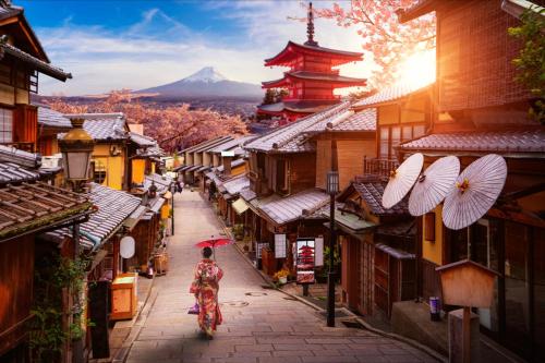 a woman walking down a street with a mountain in the background at ゆいの宿大阪城east1号室 in Osaka