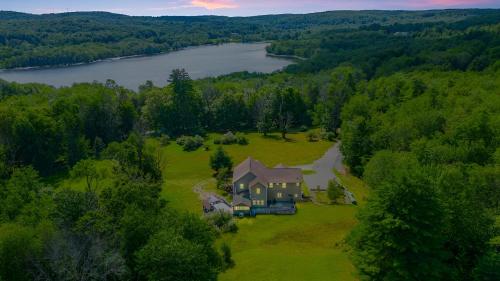 an aerial view of a large house on a field with a lake at Peaceful Paradise , Dream Holiday Home in Woodridge in Mountain Dale