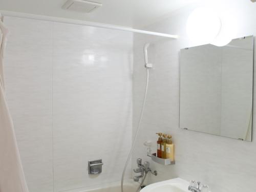 une salle de bain blanche avec un miroir et un lavabo dans l'établissement Pine Shima Resort Coral Fish - Vacation STAY 37446v, à Ibaruma
