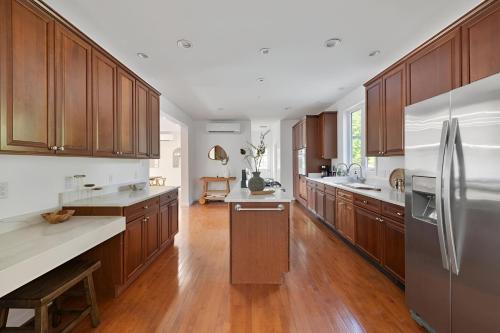 a large kitchen with wooden cabinets and stainless steel appliances at Peaceful Paradise , Dream Holiday Home in Woodridge in Mountain Dale