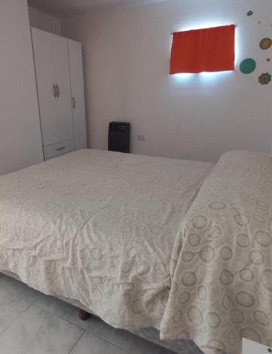 ein Schlafzimmer mit einem Bett und einem roten Fenster in der Unterkunft Jeleta 1 in Puerto Madryn