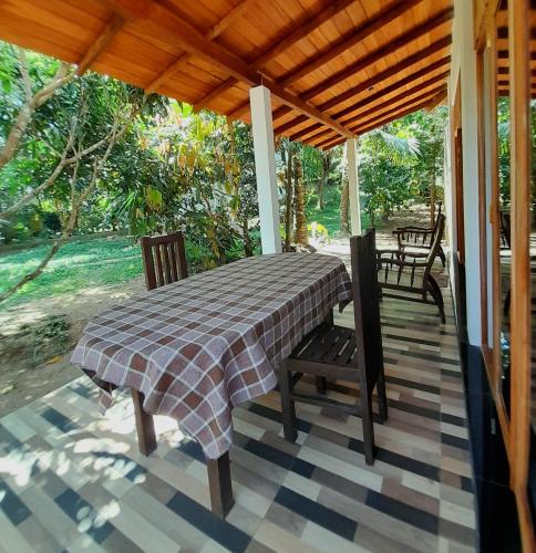 una veranda coperta con tavolo e sedie di Dinuri villa a Tangalle
