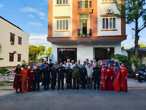 a group of people posing for a picture in front of a building at View Nhat Le Beach Hotel in Dong Hoi