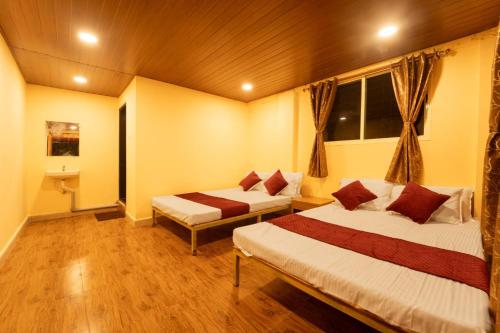 a bedroom with two beds and a window at New river side cottages in Dandeli