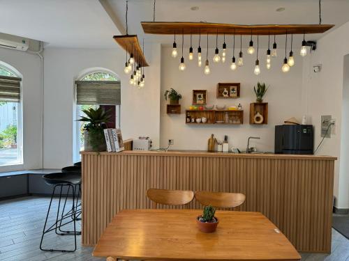 a kitchen with a wooden counter and a wooden table at Lá Homestay in Mỹ Phước