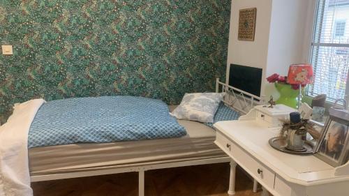 a bedroom with a bed and a desk and a wall at Rosis Gästezimmer in Oed