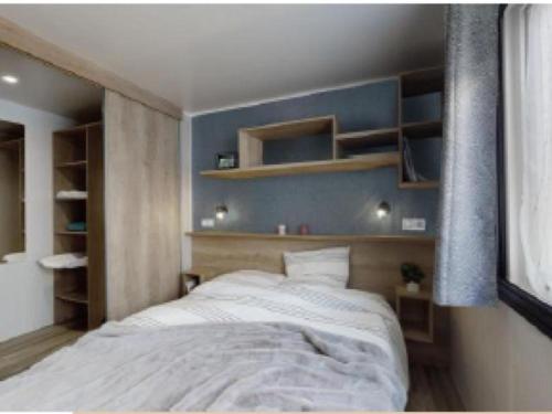 une chambre avec un lit avec un mur bleu dans l'établissement MH 541 Spacieux 40m2 avec 2 chambres 1 salle de bain dans Camping 4 étoiles, à Saint-Julien-en-Born
