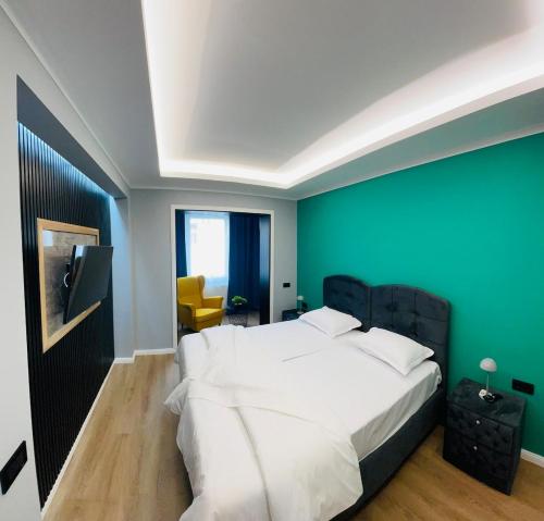 a bedroom with a white bed and a green wall at Modernes LuxusApartment in Essen in Essen