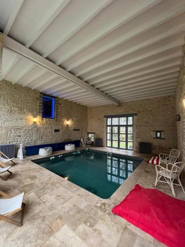 - une piscine avec un tapis rouge dans la chambre dans l'établissement Belle Grange en pierre avec piscine chauffée, à Saint-ouen-de-la-Cour