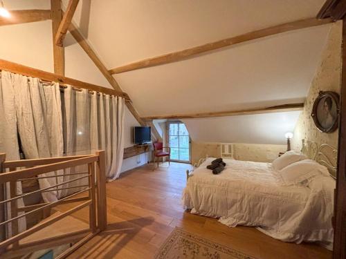 une chambre avec un lit blanc dans une pièce dans l'établissement Belle Grange en pierre avec piscine chauffée, à Saint-ouen-de-la-Cour