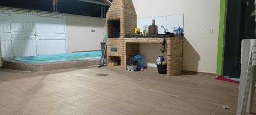 a living room with a fireplace and a bath tub at Casa com piscina e churrasqueira para família in Marechal Deodoro