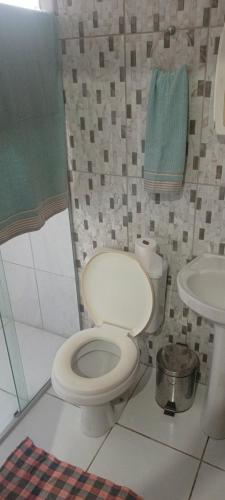 a bathroom with a toilet and a sink at Casa com piscina e churrasqueira para família in Marechal Deodoro