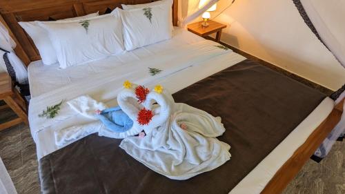 a bed with two dolls dressed in white at Lake view nest in Tangalle