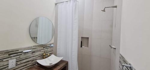 a white bathroom with a sink and a mirror at Hotel El Encuentro in Tochimpa