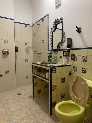 a bathroom with a green toilet and a sink at Hotel El Encuentro in Tochimpa