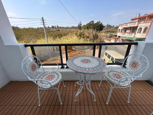 a balcony with a table and chairs on a balcony at 藍月金門民宿 in An-ch'ien