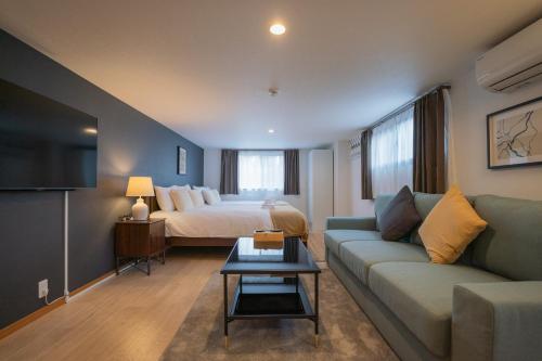 a living room with a couch and a bed at 博文ビル in Osaka
