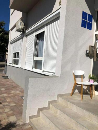 a chair and a table in front of a building at Mikulić Apartments in Zadar
