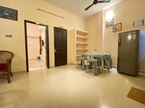 une pièce avec une table et des chaises et une porte noire dans l'établissement La Dreamy Beach Residency, à Pondichéry