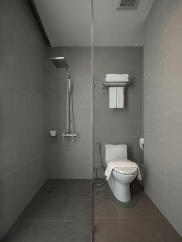 a bathroom with a toilet and a shower at Norma Hotel Sathorn - Formerly T2 Residence Sathorn in Bangkok