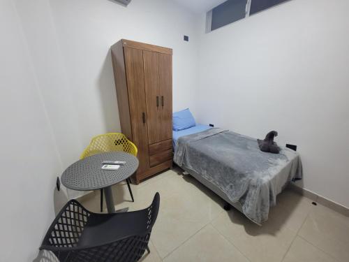 une chambre avec un lit, une table et des chaises dans l'établissement Jose Andres Mini Suite 4, à San Cristóbal