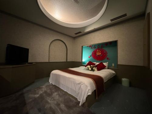 a bedroom with a large bed with a large painting on the wall at ホテル オリエント in Takasaki