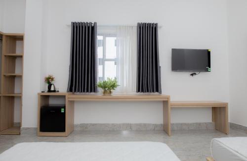 a living room with a table and a tv at Miền Tây Hotel in Can Tho