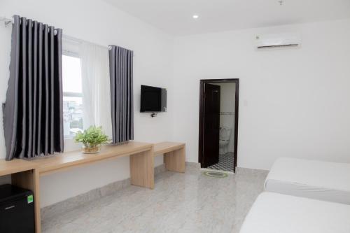 a room with a bed and a window with a television at Miền Tây Hotel in Can Tho