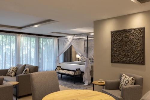 a bedroom with a bed and a room with chairs at Pax Manor Muthaiga in Nairobi