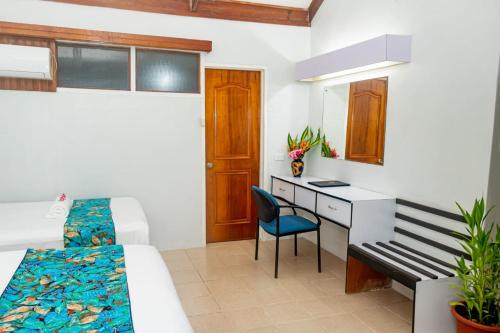 a bedroom with a bed and a desk and a chair at Honiara Hotel in Honiara
