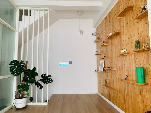 a hallway with wooden walls and a potted plant at Burabura Cafe Guesthouse in Donggang