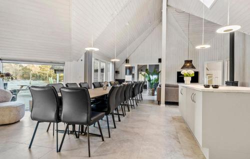 a dining room with a long table and black chairs at Amazing Home In Rømø With Sauna in Toftum