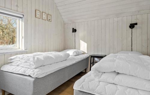 two beds sitting in a room with a window at Amazing Home In Rømø With Sauna in Toftum