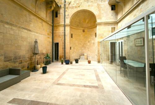 a large room with a stone building with a glass door at Valletta St Ursula in Valletta