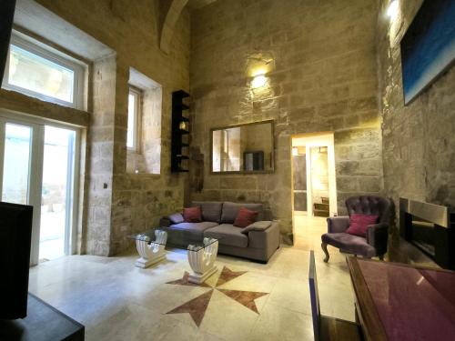 a living room with a couch and two chairs at Valletta St Ursula in Valletta